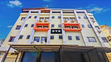 A multi-story building with balconies, air conditioning units, and a sign with the letters 'OYO'.