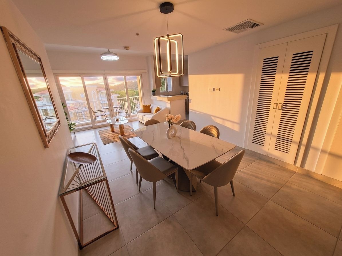A modern dining area with a large marble table, contemporary chairs, and a pendant light.