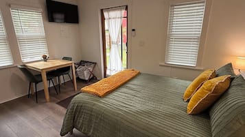 Una camera da letto con un letto, una scrivania e una televisione.