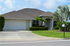 A single-story house with a garage, a driveway, and a well-maintained lawn. - Luxury 3 Bedroom Villa (Rotonda West)