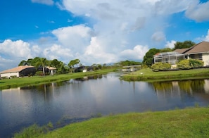 A residential area with a pond, houses, and a covered structure. - Luxury 3 Bedroom Villa (Rotonda West)