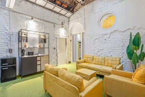 A modern interior with a kitchen area, seating, and a unique circular window. - Quiet Studio Facing the Courtyard | Karmelitermarkt | Self-Check-In (Wien)