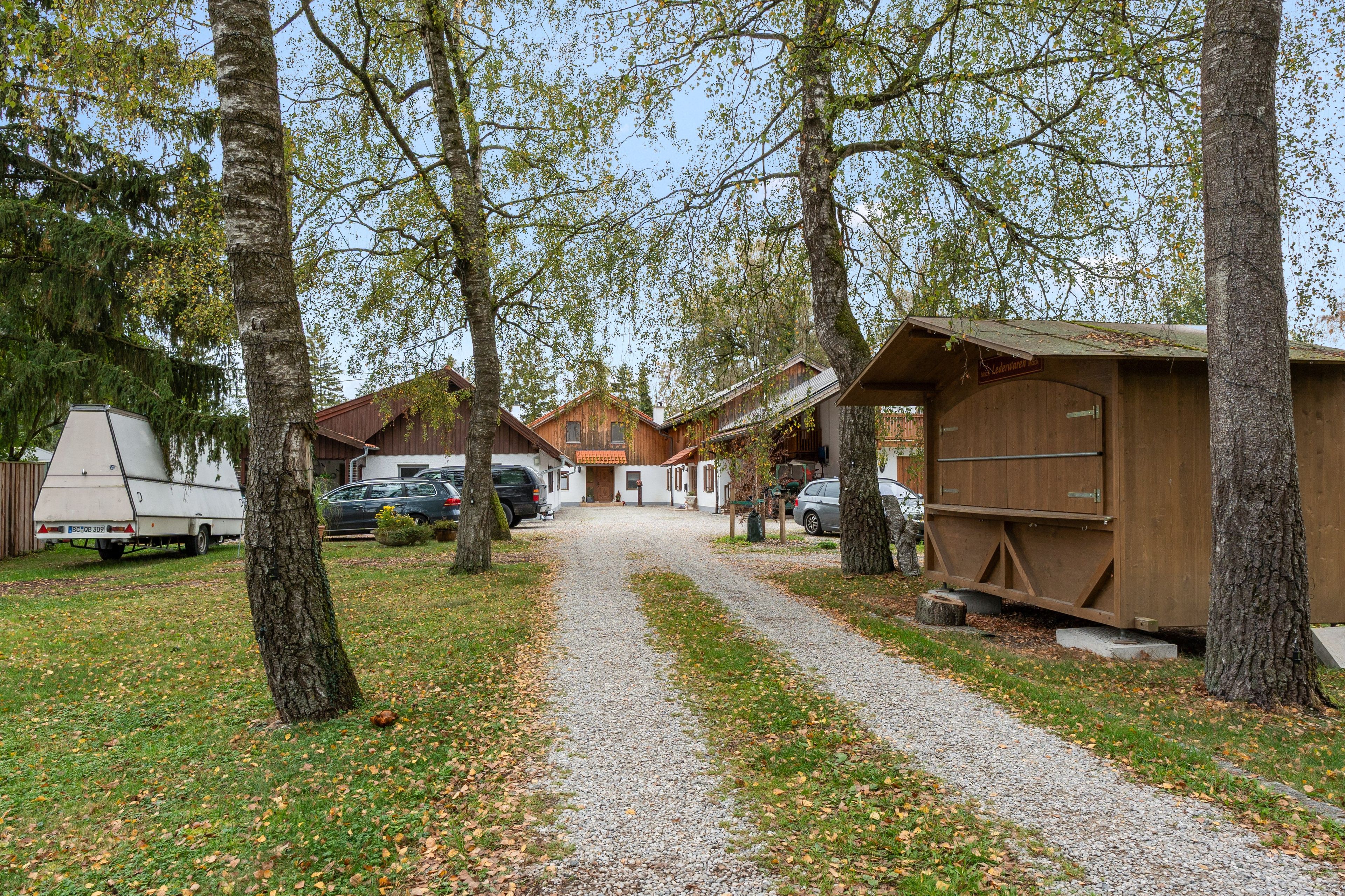 A gravel path leading to a row of wooden cabins with a clear sky above.