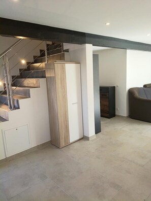 A modern interior with a staircase, a built-in cabinet, a sofa, and a fireplace. - New! Meerzeit Vacation Home (Nenndorf)