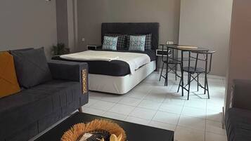 Un dormitorio moderno con cama, mesitas de noche, un escritorio y una silla.