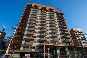 A multi-story building with a modern architectural design, featuring balconies on each floor. - Studio in Condo. w/ Pool & City View Skg0503 (Porto Alegre)