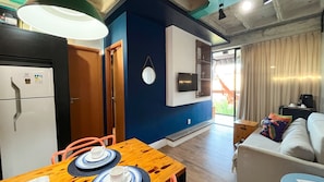 A compact living space with a kitchenette, a dining area, and a seating area with a view. - Condominio Merepe Residence - Porto de Galinhas (Ipojuca)