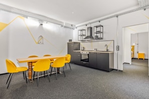 A modern kitchen with a dining area, featuring a central island, built-in appliances, and a minimalist design. - 2 bedrooms with a terrace | Karmelitermarkt | 6 guests (Wien)