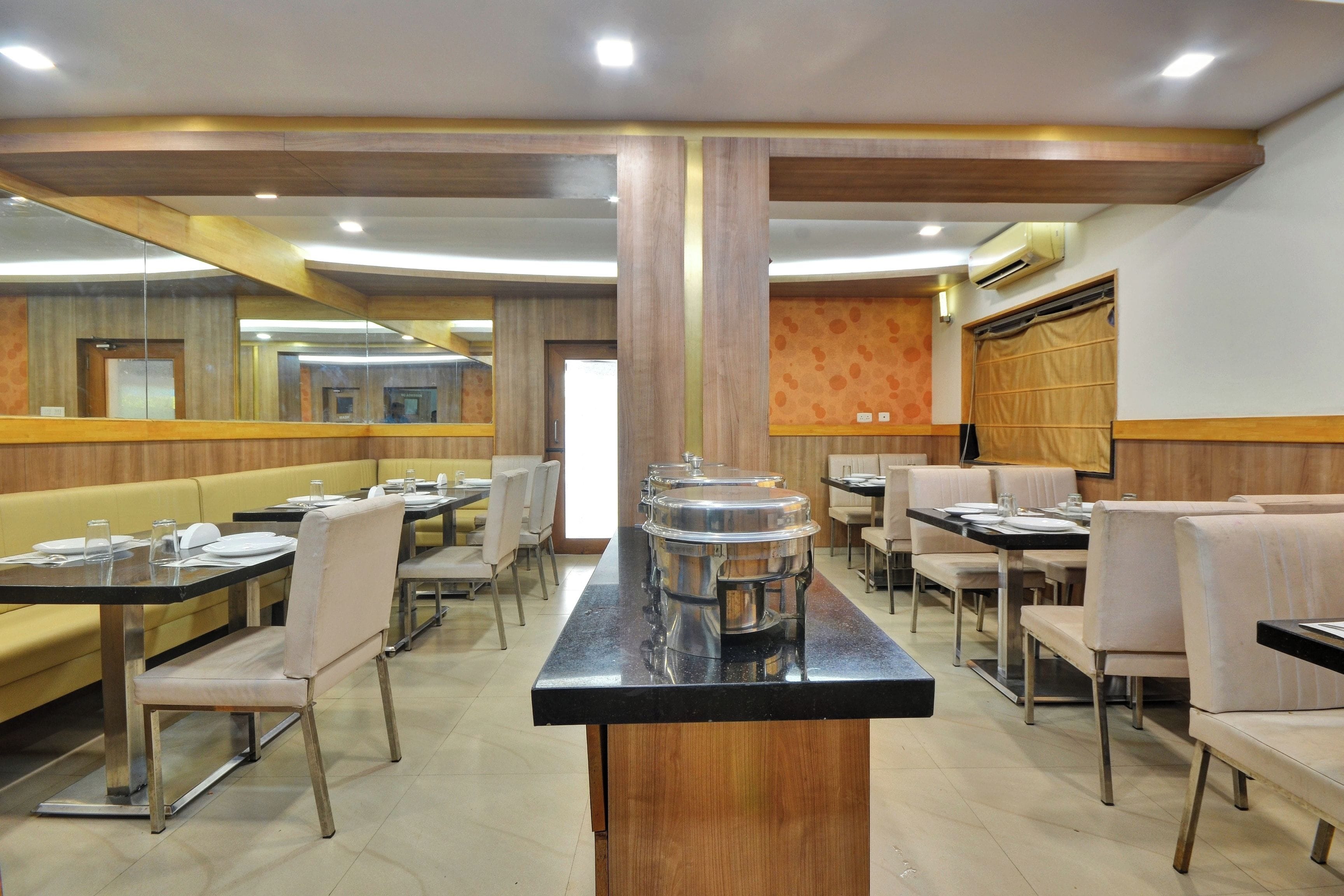 A restaurant with booth seating, round tables, and a central serving station.