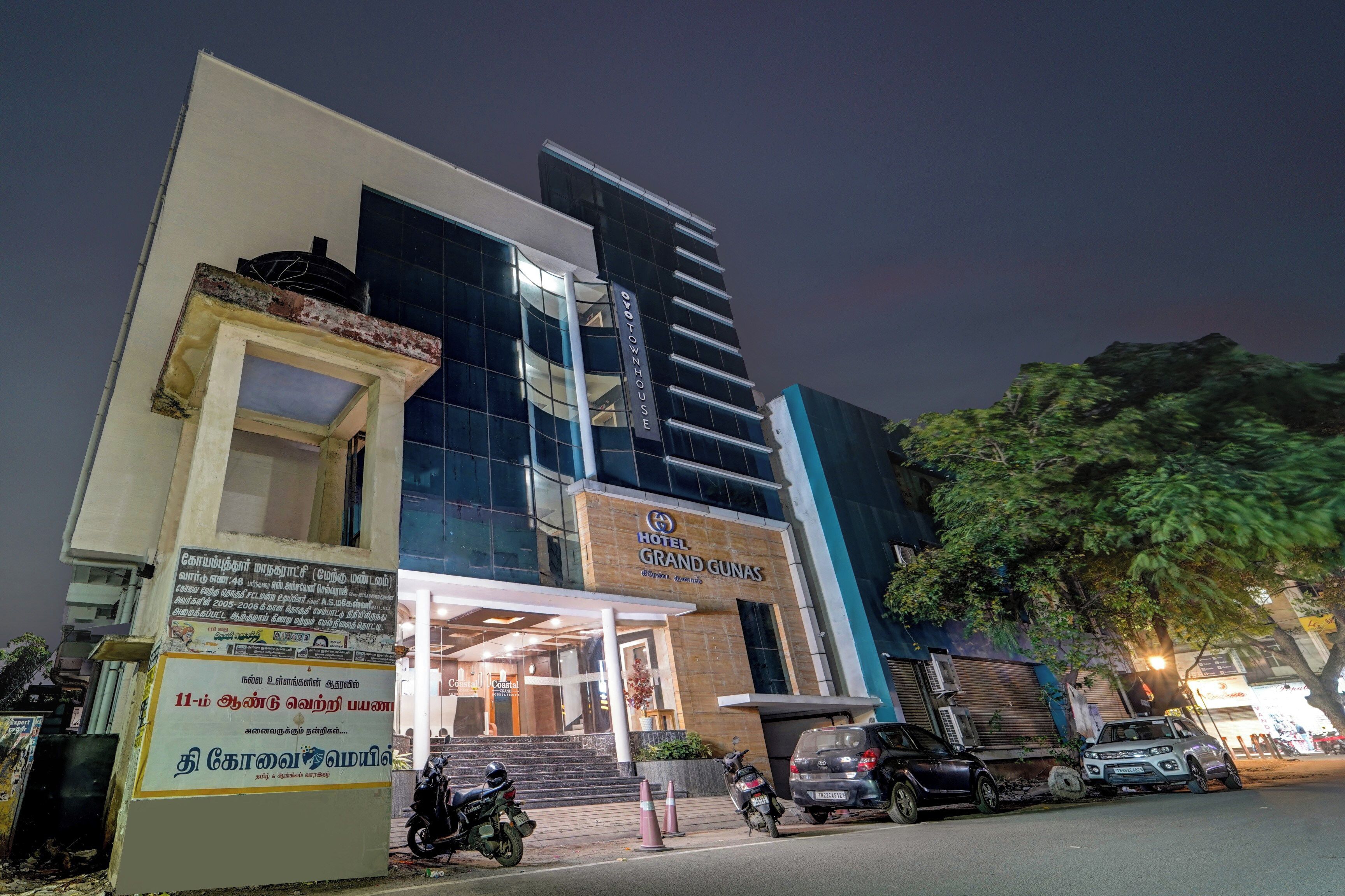 A hotel with a modern facade, a visible entrance, and a signboard with text.