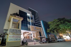 A hotel with a modern facade, a visible entrance, and a signboard with text.