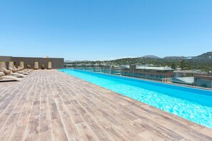 A rooftop pool with a wooden deck, lounge chairs, and a view of the surrounding landscape. - Newlands Peak Studio with AC and gym (Cape Town)