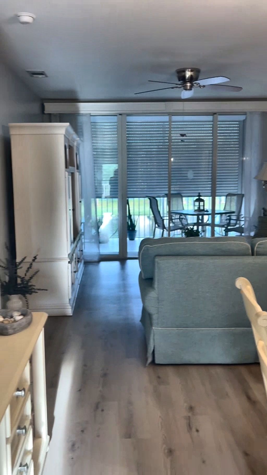 En stue med sofa, træskab og loftventilator.