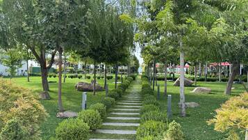 Un jardín ajardinado con un sendero de piedra, árboles y arbustos bien cuidados.
