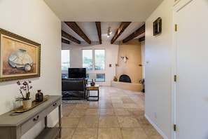 Un salón amplio con chimenea, televisor y comedor con mesa y sillas.