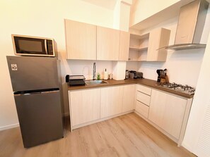 Eine kompakte Küche mit Einbau-Mikrowelle, Spüle und Herd.
