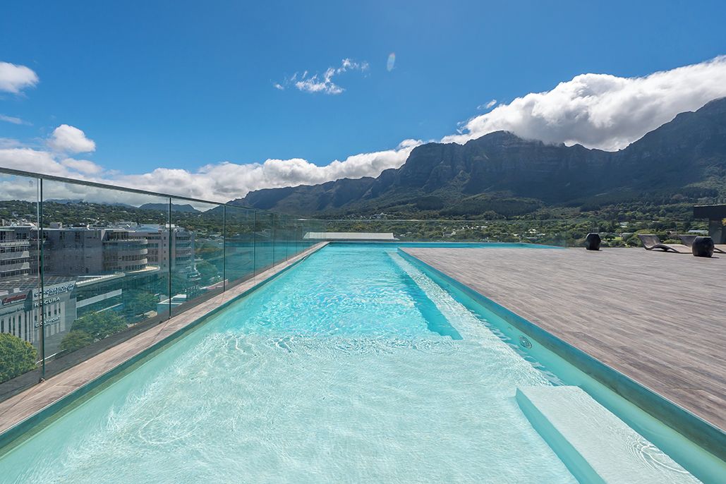 Une piscine sur le toit offrant une vue dégagée sur les montagnes en arrière-plan.