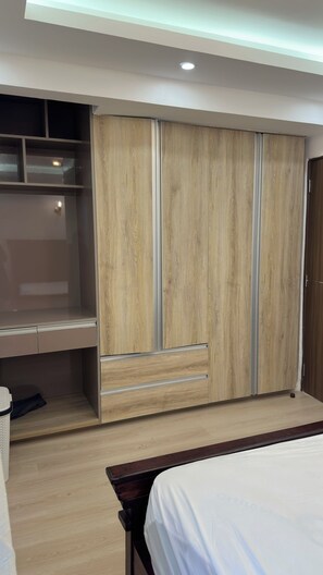 Une chambre à coucher avec un lit, une armoire avec un miroir et une table de chevet.