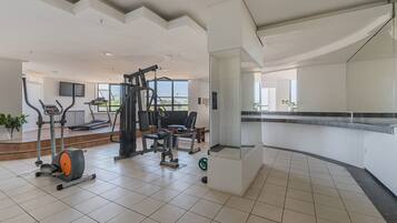 A gym with various exercise equipment, a treadmill, and a weight bench.