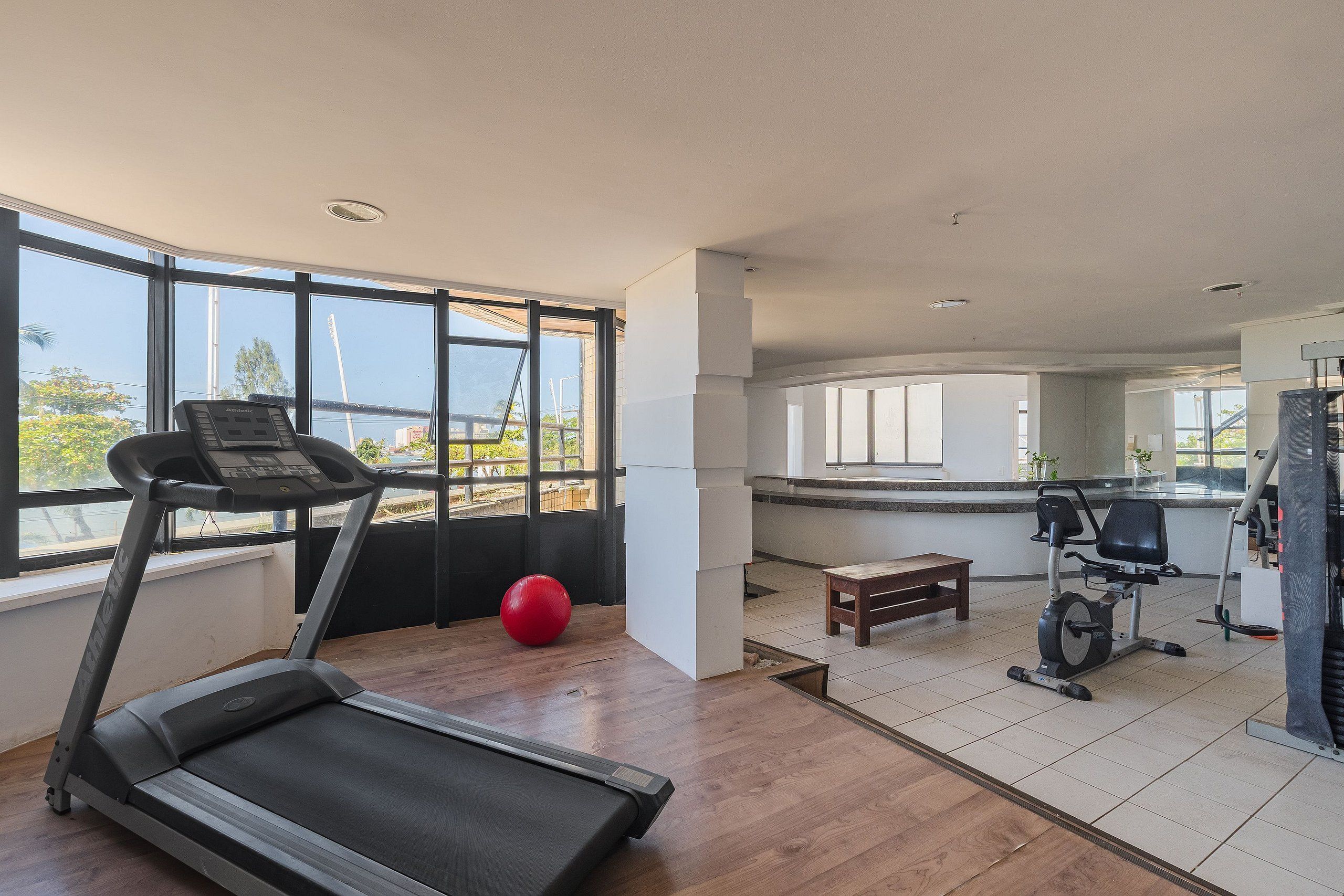 A gym with a treadmill, exercise ball, and stationary bike.