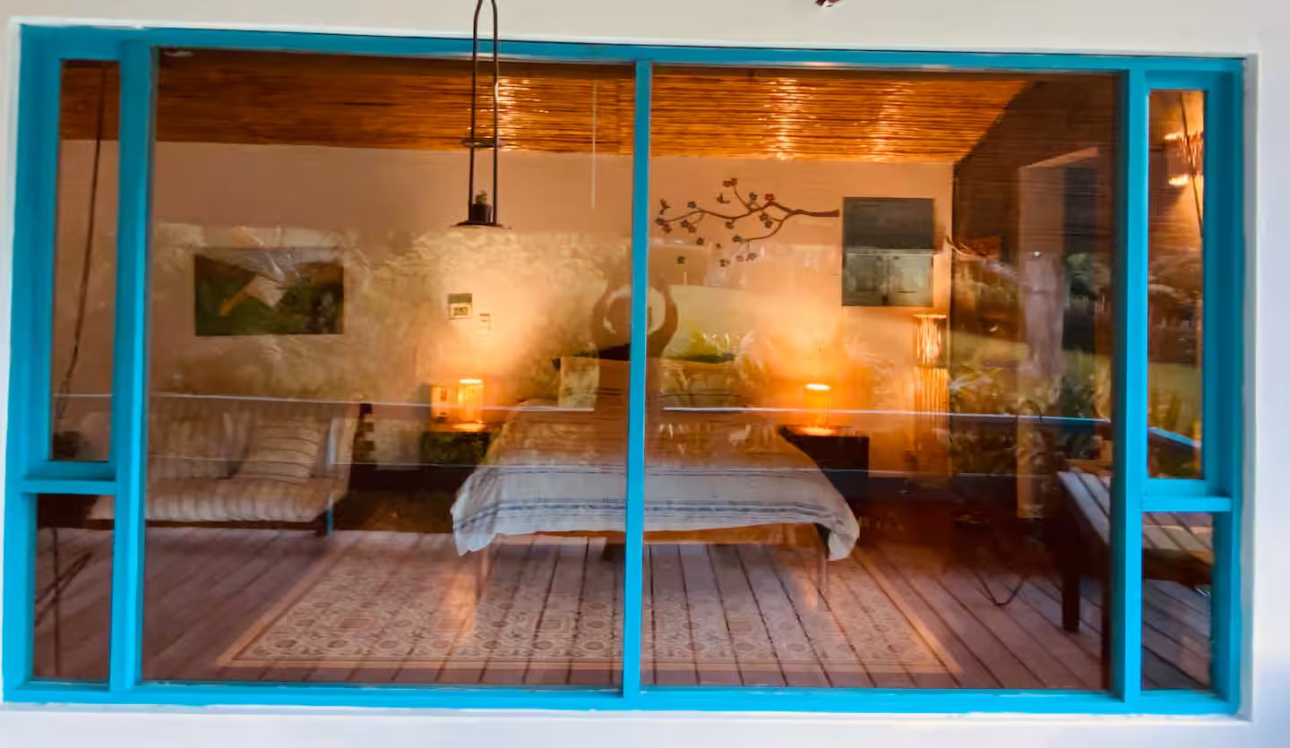 A room with a bed, a nightstand, a lamp, and a wall-mounted artwork.