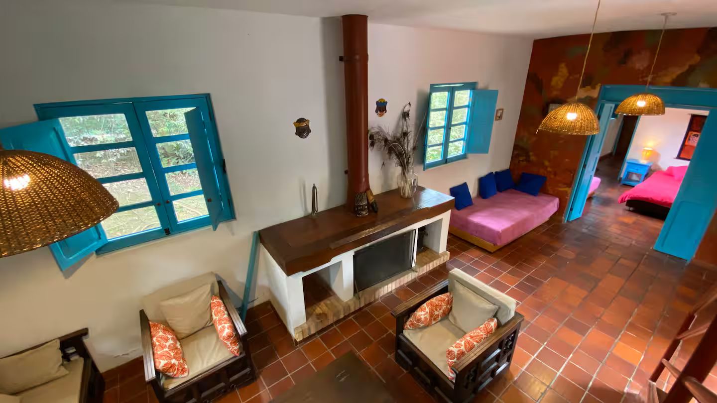 A room with a sofa, a small table, and a window with blue shutters.