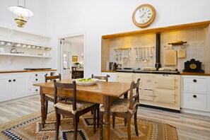 A traditional kitchen with a wooden table, chairs, and a clock on the wall. - Raithbury Hill House (Stellenbosch)