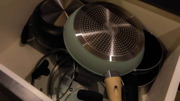 A kitchen drawer containing various cookware items including pots and pans.