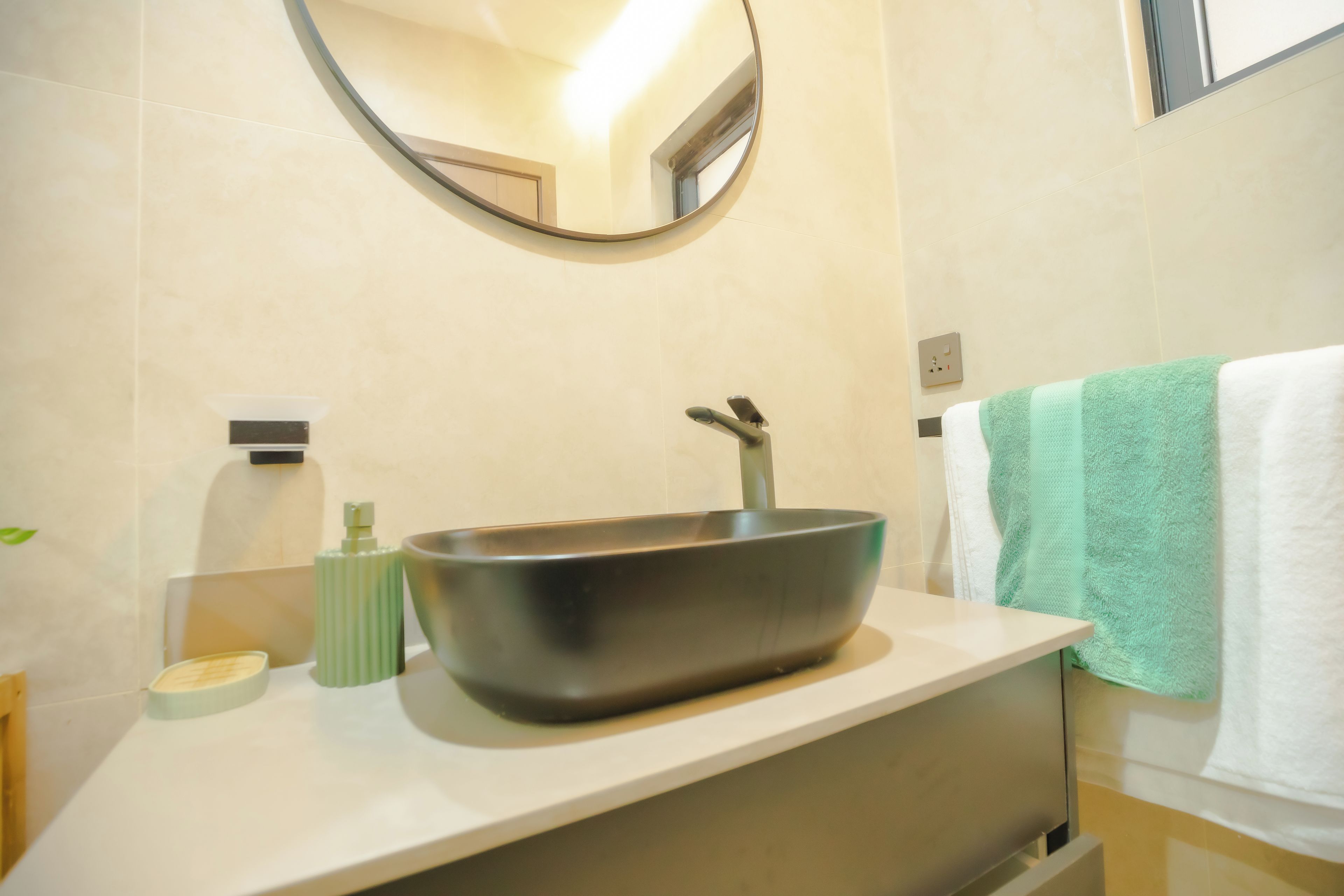A modern bathroom with a vessel sink, a mirror, and a towel rack.