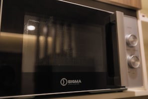 A black microwave oven with a metallic finish and a logo that reads 'SIGMA APPLIANCES'. - Beaufort Ridge (Accra)