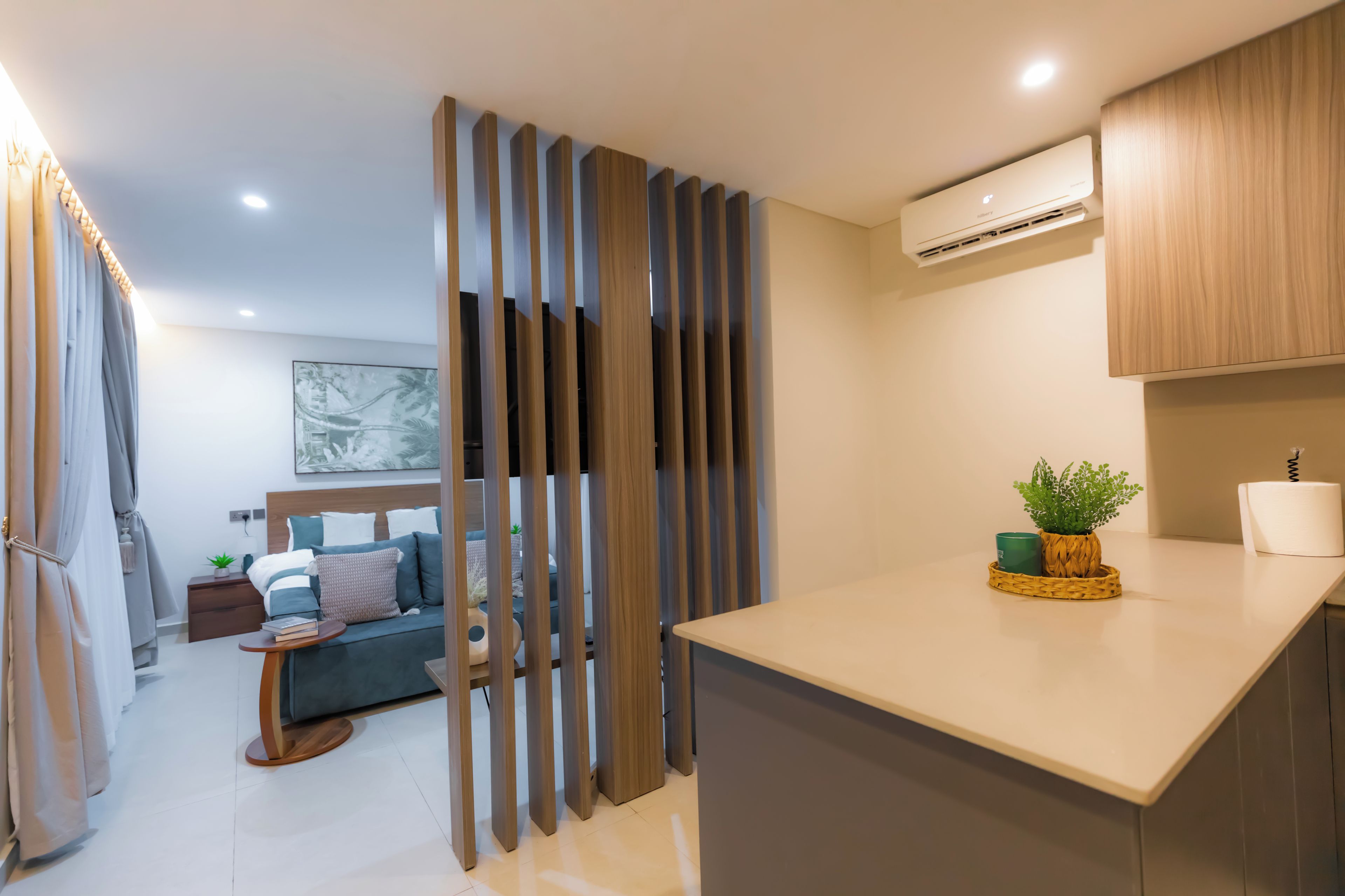 Une chambre d’hôtel moderne dotée d’une kitchenette, d’un coin repas et d’un espace de vie.