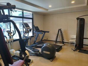A gym with exercise equipment including treadmills, an elliptical, and a weight bench. - Geowisata Inn (Bandung)