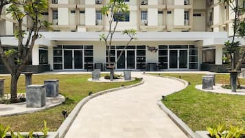 Un edificio con un patio central, rodeado de árboles y bancos.