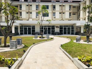 A building with a central courtyard, surrounded by trees and benches. - Geowisata Inn (Bandung)