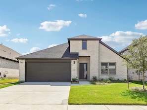 A modern two-story house with a garage, a well-maintained lawn, and a clear sky. - Modern 4BR Home • Office • Patio • 3 Full Baths (McKinney)