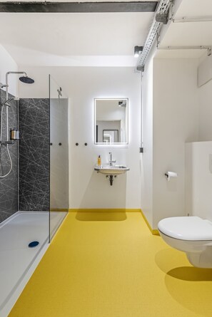A modern bathroom with a shower, sink, and toilet. - Studio with private terrace | Karmelitermarkt (Wien)