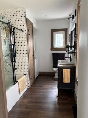 A bathroom with a shower, toilet, and sink.