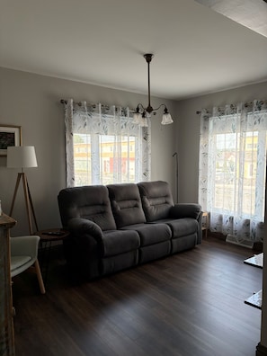A living room with a dark brown sofa, a standing lamp, and a floor lamp.
