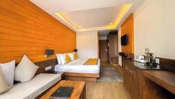 Een hotelkamer met een bed, een slaapbank, een bureau en een televisie.