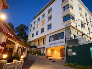 Um hotel com vários andares e fachada moderna, entrada visível e placa indicando que é um resort e spa.