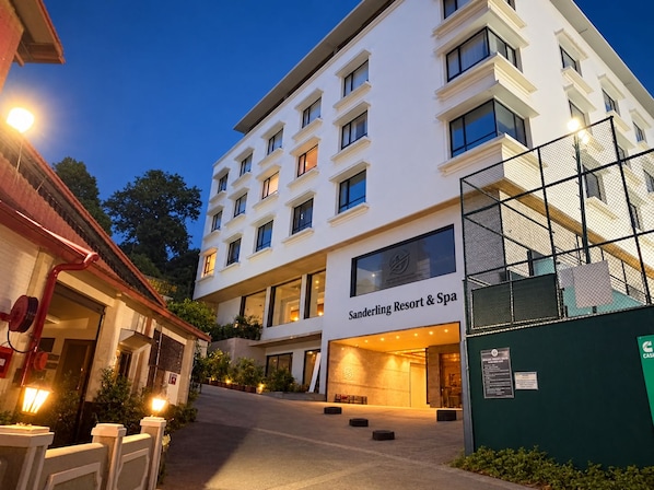 Un hotel de varios pisos con fachada moderna, una entrada visible y un letrero que indica que es un complejo turístico y spa.