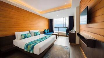Een moderne hotelkamer met een groot bed, houten lambrisering, een flatscreen televisie en uitzicht op de lucht.