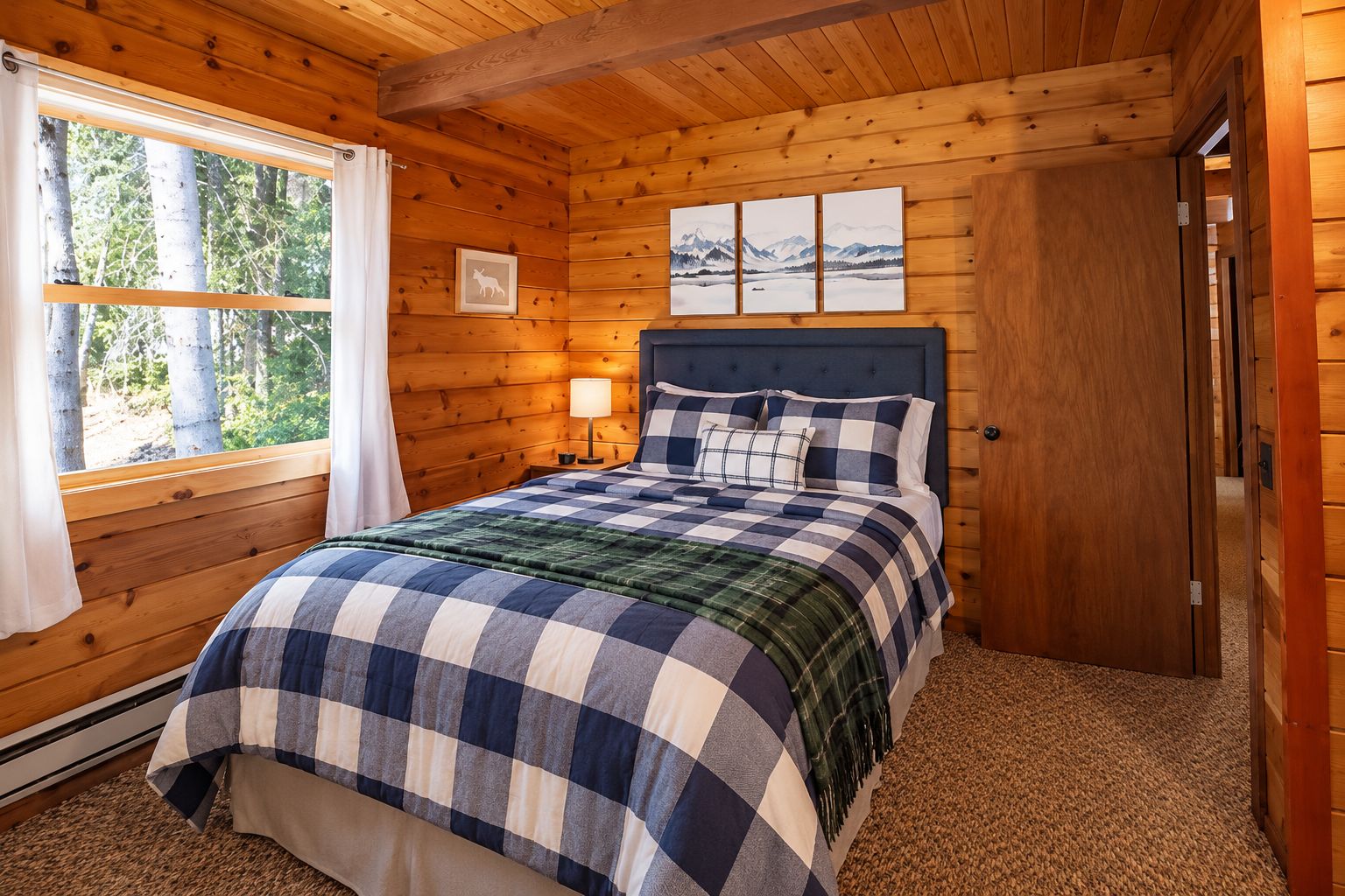 Ein Schlafzimmer einer Holzhütte mit einem Bett, einem Nachttisch, einem Fenster mit Vorhängen und einer Tür.