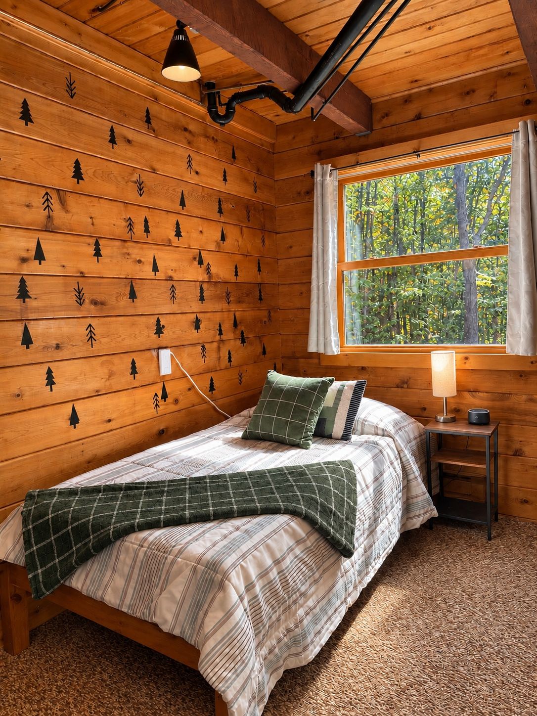 Une chambre à coucher dans une cabane en bois, avec un lit, une table de chevet, une lampe et une fenêtre donnant sur la forêt.