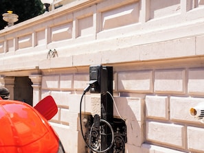 A vehicle charging station mounted on a white brick wall with decorative moldings. - Le Clos du Breuchin (Breuchotte)