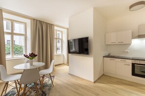 A modern kitchen with a built-in oven and a flat-screen TV mounted on the wall. - 1-Bedroom Apartment | Naschmarkt | Sleeps 4 | Self-Check-In (Wien)