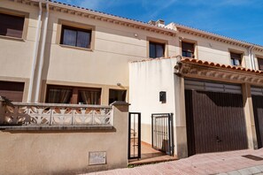 A two-story building with a beige facade, a gated entrance, and a garage door. - La Bienservida Country House (Bienservida)