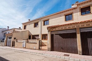 A residential building with a garage, a gated entrance, and a clear sky.