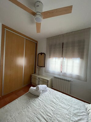 A bedroom with a bed, a ceiling fan, a wardrobe, a dresser, and a window with curtains. - La Bienservida Country House (Bienservida)