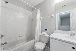 A bathroom with a bathtub, toilet, and sink. - 4-bedroom House in Regal Oaks Near Disney (Kissimmee)